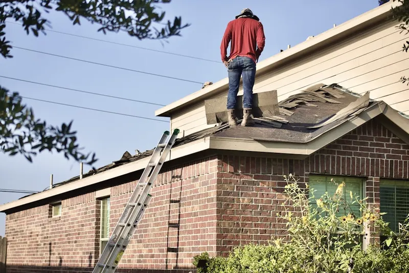 Professional roofer working on a residential roof in Poncey-Highland